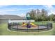 A charming community playground with a slide, climbing structure, and protective black fence, with a building nearby at 2559 Eagle Bay Blvd, Kissimmee, FL 34743