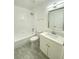 Bathroom with a tub shower, toilet, and sink with modern fixtures at 305 S Palm Ave, Kissimmee, FL 34741