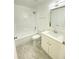 Bathroom with a tub shower, toilet, and sink with modern fixtures at 305 S Palm Ave, Kissimmee, FL 34741