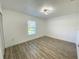 Bright bedroom features wood-look flooring and a modern ceiling light fixture at 305 S Palm Ave, Kissimmee, FL 34741