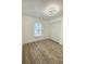 Bedroom features wood-look flooring, a modern ceiling light, and a closet at 305 S Palm Ave, Kissimmee, FL 34741