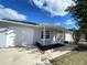 The front of this single-story house features an attractive, landscaped yard and a freshly painted exterior at 305 S Palm Ave, Kissimmee, FL 34741