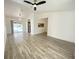 Spacious living room with wood-look flooring, slider to lanai, and a stylish modern ceiling fan at 305 S Palm Ave, Kissimmee, FL 34741