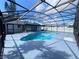 Screened-in pool with blue water surrounded by a concrete patio and privacy fence at 305 S Palm Ave, Kissimmee, FL 34741