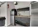 Garage kitchenette featuring modern cabinetry, marble backsplash, mini fridge, and sink at 33 Perch Dr, Kissimmee, FL 34759