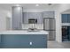 Stylish kitchen with blue cabinets, stainless steel appliances, a kitchen island and tiled backsplash at 33 Perch Dr, Kissimmee, FL 34759