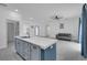 Contemporary kitchen with a quartz island, blue cabinetry, and modern appliances, connecting to a living space at 33 Perch Dr, Kissimmee, FL 34759