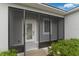 Inviting screened front porch featuring white trim, screen, and manicured shrubbery at 33 Perch Dr, Kissimmee, FL 34759