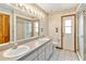 Bright bathroom featuring dual sinks, white tile flooring, and a glass-enclosed shower at 3619 Willow Lake Ct, St Cloud, FL 34769