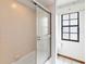 Bathroom featuring a glass enclosed bathtub/shower with tile surround, and a window at 3619 Willow Lake Ct, St Cloud, FL 34769