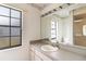 Bathroom features a vanity with ample lighting, a large mirror and a view of the shower at 3619 Willow Lake Ct, St Cloud, FL 34769