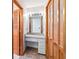 Bathroom featuring a makeup vanity with storage, wood paneled doors, and carpet flooring at 3619 Willow Lake Ct, St Cloud, FL 34769