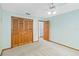 Bedroom showcases neutral carpet, blue walls, ceiling fan and expansive closet with wood paneled doors at 3619 Willow Lake Ct, St Cloud, FL 34769