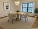 A dining room features a round table, four chairs, a modern light fixture, and natural light at 3619 Willow Lake Ct, St Cloud, FL 34769