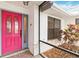 Close-up of a vibrant pink front door, framed by white brick and lush greenery at 3619 Willow Lake Ct, St Cloud, FL 34769