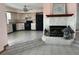 Inviting living room featuring a stone fireplace and seamless flow to the kitchen with a ceiling fan at 3619 Willow Lake Ct, St Cloud, FL 34769