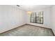 An empty room featuring wall-to-wall carpeting, wood baseboards, a modern light fixture and a single window at 3619 Willow Lake Ct, St Cloud, FL 34769