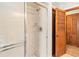Bathroom featuring a tiled shower with glass door and silver hardware, paired with wood paneled doors at 3619 Willow Lake Ct, St Cloud, FL 34769