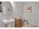 Charming powder room features pedestal sink, decorative accents, and a colorful, framed art piece at 3987 Meandering Bay Dr, Apopka, FL 32712