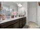 Bathroom featuring double sinks, quartz countertop, dark cabinetry, and modern fixtures at 3987 Meandering Bay Dr, Apopka, FL 32712
