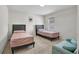 This bedroom features two twin beds and a soft, teal love seat at 3987 Meandering Bay Dr, Apopka, FL 32712