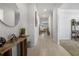 Inviting hallway with light tile floors features decor and flows into the open living spaces at 3987 Meandering Bay Dr, Apopka, FL 32712