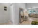 Inviting hallway with stylish mirror and decor, leading to a bright living area with large windows at 3987 Meandering Bay Dr, Apopka, FL 32712