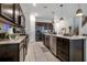 Modern kitchen with stainless steel appliances, dark cabinets, and an island with a dishwasher at 3987 Meandering Bay Dr, Apopka, FL 32712