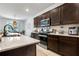 Well-appointed kitchen with quartz countertops, stainless steel appliances, and dark wood cabinetry at 3987 Meandering Bay Dr, Apopka, FL 32712