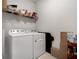 Well-equipped laundry room with modern washer, dryer, and ample storage space on wire shelving at 3987 Meandering Bay Dr, Apopka, FL 32712
