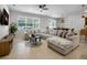 Bright living room with a large sectional, tiled floors, and a view to the backyard at 3987 Meandering Bay Dr, Apopka, FL 32712