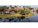 Stunning aerial view of community buildings with palm trees, waterway, and lush landscaping creating a tropical paradise at 4311 Via Cavour Ct, Kissimmee, FL 34759