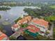 Aerial view of lakeside town center featuring red tile roofs, lush trees, and a bridge at 4311 Via Cavour Ct, Kissimmee, FL 34759