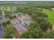 An aerial view of tennis courts surrounded by lush green foliage, providing a private recreational space at 4311 Via Cavour Ct, Kissimmee, FL 34759