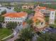 Community aerial view with red-tiled rooftops, surrounding lake, and mature trees creating a peaceful and inviting atmosphere at 4311 Via Cavour Ct, Kissimmee, FL 34759