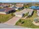 An aerial view of a single-Gathering home with paver driveway, lush lawn, and a serene pond nearby at 4311 Via Cavour Ct, Kissimmee, FL 34759