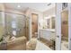 Bathroom with a glass-enclosed shower, dual sinks, and white cabinets at 4311 Via Cavour Ct, Kissimmee, FL 34759