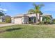 Well-maintained single-story home with a manicured lawn, colorful landscaping, and a spacious two-car garage at 4311 Via Cavour Ct, Kissimmee, FL 34759