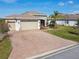 Charming single-Gathering home boasting a three-car garage, paver driveway, and well-manicured lawn at 4311 Via Cavour Ct, Kissimmee, FL 34759
