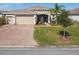 Inviting single-Gathering home featuring a lush green lawn, mature landscaping, and a paver driveway at 4311 Via Cavour Ct, Kissimmee, FL 34759