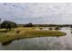 Scenic view of lush green golf course with pond on a cloudy day at 4311 Via Cavour Ct, Kissimmee, FL 34759