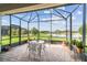 The screened-in lanai features brick flooring and panoramic water views at 4311 Via Cavour Ct, Kissimmee, FL 34759