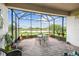 Covered screened-in lanai with brick flooring and scenic view of the pond at 4311 Via Cavour Ct, Kissimmee, FL 34759