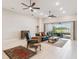 Open living room with wood-look tile, ceiling fans, and large sliding doors to the patio at 4311 Via Cavour Ct, Kissimmee, FL 34759