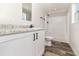 Bright bathroom features a modern vanity with granite countertop, wood look flooring, and a shower at 4626 Bunting Ave, Orlando, FL 32812