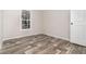 Cozy bedroom offers new wood-look floors, neutral paint, and a bright window at 4626 Bunting Ave, Orlando, FL 32812