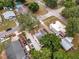 An aerial view shows the property nestled among mature trees in a neighborhood with access to roads and community pool at 528 S 8Th St, Lake Wales, FL 33853