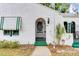 Charming white home with green trim, arched doorway, awning, flagpole, and unique textured facade at 528 S 8Th St, Lake Wales, FL 33853
