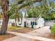 Charming white home with green trim, arched doorway, awning, flagpole, and unique textured facade at 528 S 8Th St, Lake Wales, FL 33853