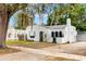 Charming white home with green trim, arched doorway, awning, flagpole, and unique textured facade at 528 S 8Th St, Lake Wales, FL 33853